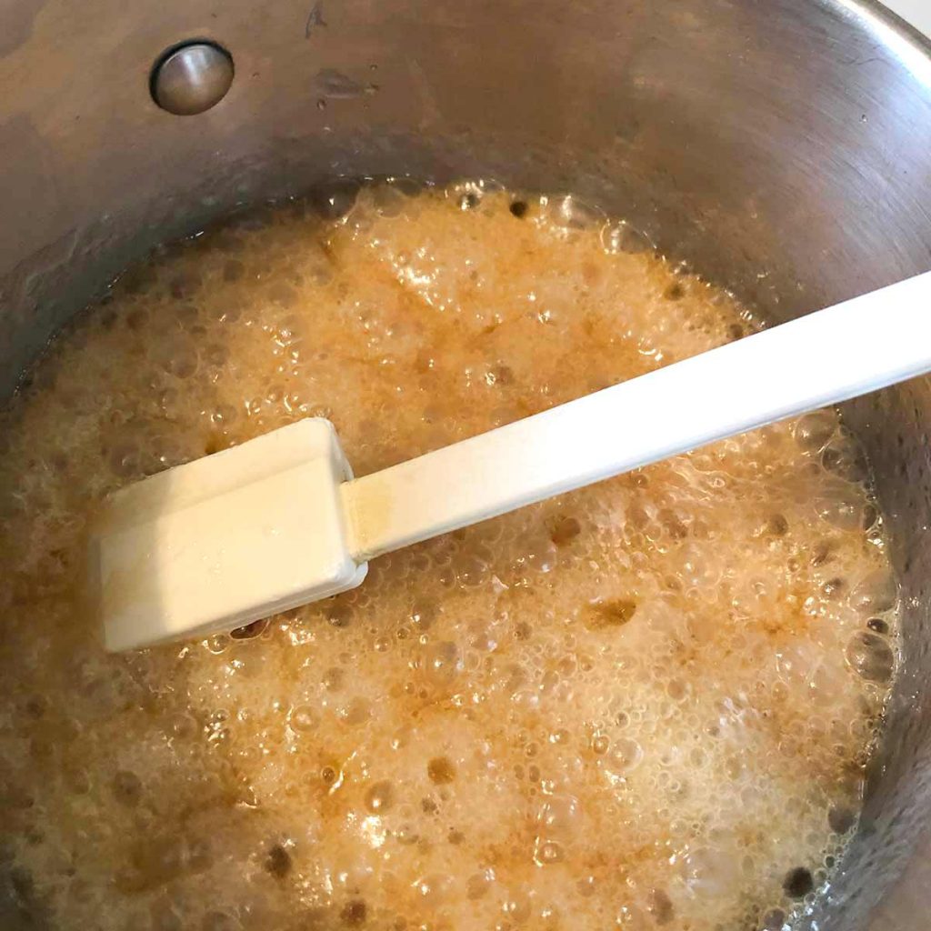 browning caramel sauce in pan with spatula