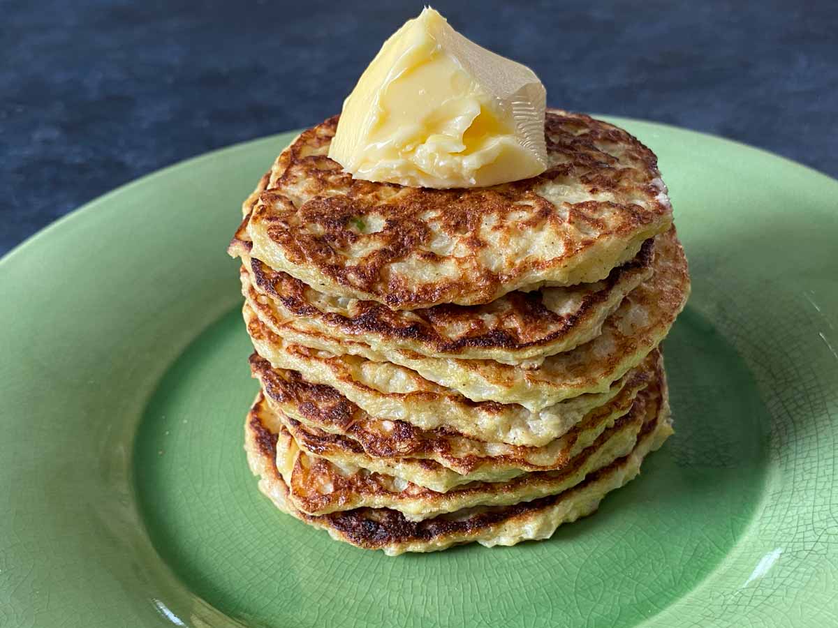 stack of cauliflower patties with butter on plate