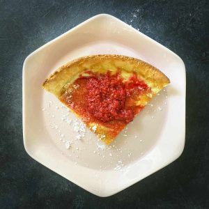 Keto dutch baby slice on plate with raspberries