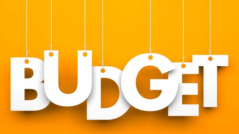 budget sign white block letters on yellow orange background